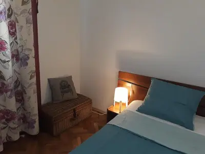 a bedroom with a bed and a chair and a lamp at 500 steps to the sand in Varna City