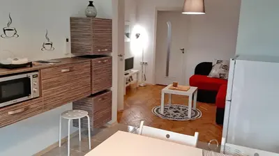 a kitchen with a refrigerator and a red couch at 500 steps to the sand in Varna City
