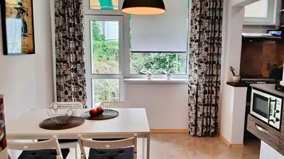 a kitchen with a table and chairs and a window at 500 steps to the sand in Varna City