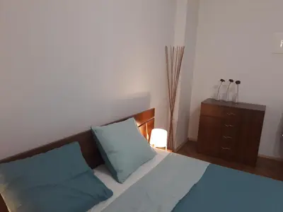 a bedroom with a bed with blue pillows and a dresser at 500 steps to the sand in Varna City