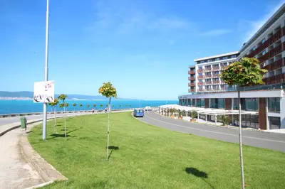 a grassy area with palm trees in front of a building at PARADISO 308-309 Private Studios Nessebar in Nesebar