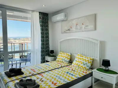 a bedroom with a bed and a balcony at PARADISO 308-309 Private Studios Nessebar in Nesebar