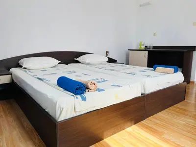 a large bed with a teddy bear laying on it at Paunovi Guest House in Primorsko