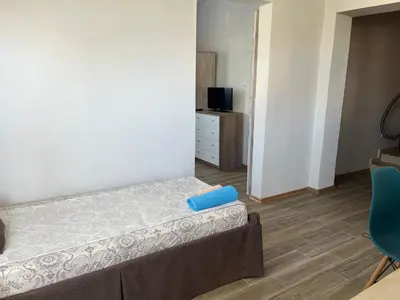a small room with a bed and a chair at Paunovi Guest House in Primorsko