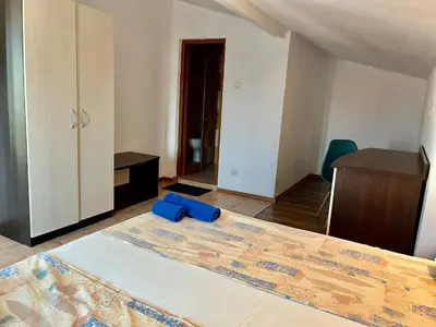 a bedroom with a bed with a blue object on it at Paunovi Guest House in Primorsko