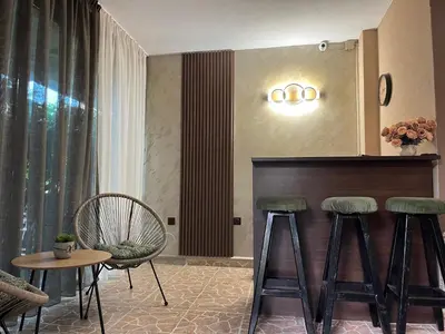 a living room with two bar stools and a table at Paunovi Guest House in Primorsko
