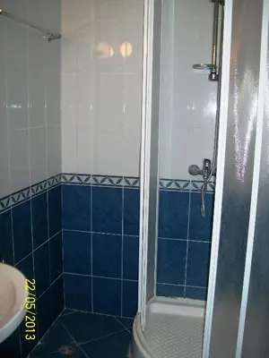 a blue tiled bathroom with a shower and a sink at Apartment in Kambani 1 Apartcomplex in Sveti Vlas