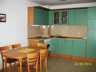 a kitchen with green cabinets and a wooden table at Apartment in Kambani 1 Apartcomplex in Sveti Vlas
