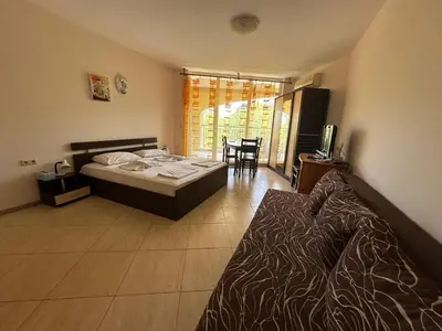 a bedroom with a bed and a table and chairs at PSB Apartments in Midia Resort Aheloy in Aheloy