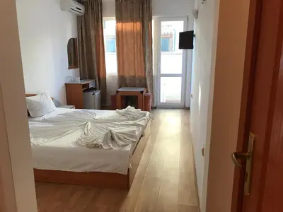 a hotel room with a bed and a hallway at Arkadia Guest House in Primorsko