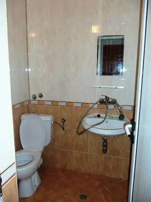 a bathroom with a toilet and a sink at Arkadia Guest House in Primorsko