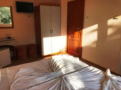 a large white bed in a room with a door at Arkadia Guest House in Primorsko