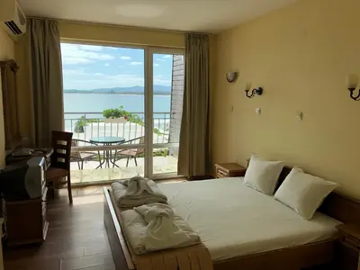 a bedroom with a bed with a view of the ocean at Family Hotel Littoral in Sozopol