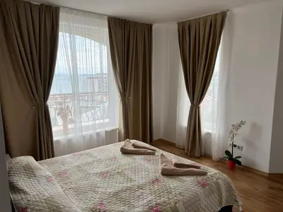 a bedroom with a bed and a large window at Antorini Apartments in Sveti Vlas