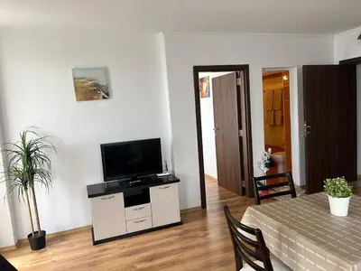 a living room with a flat screen tv on a white cabinet at Antorini Apartments in Sveti Vlas