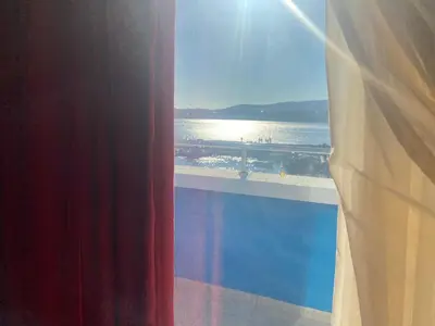a window with a view of a beach and the ocean at Ribarska Sreshta Family Hotel in Tsarevo