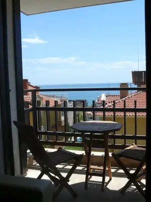 a table and chairs on a balcony with a view of the ocean at Complex Kentavar - Free Fast WiFi in Sveti Vlas