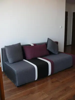 a couch with colorful pillows on top of a wooden floor at Complex Kentavar - Free Fast WiFi in Sveti Vlas