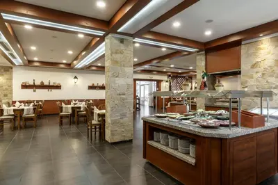 a restaurant with tables and chairs and a buffet at AluaSun Helios Beach - All Inclusive in Obzor
