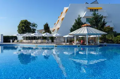 a swimming pool in front of a hotel at AluaSun Helios Beach - All Inclusive in Obzor