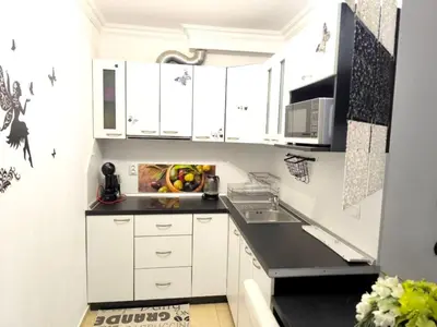 a kitchen with white cabinets and a sink at Dom-El Real Apartments Amphora in Sveti Vlas