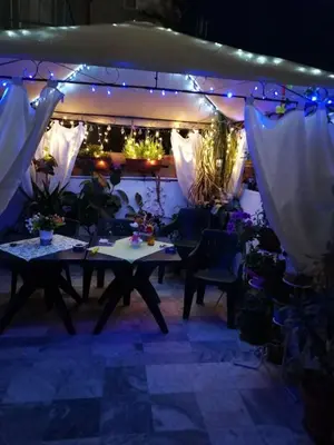 a table and chairs in a room with lights at Guest House Konomaevi in Sozopol