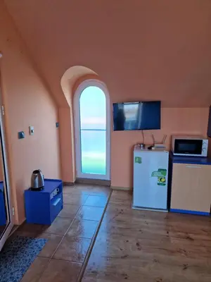 a kitchen with an arched window and a refrigerator at Dara Hotel in Primorsko