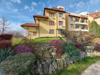 a building with a garden in front of it at Oasis Beach Apartments Kamchia in Kamchia