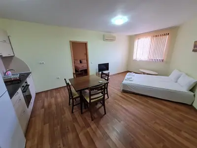 a room with a bed and a table and a couch at Oasis Beach Apartments Kamchia in Kamchia