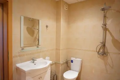 a bathroom with a white toilet and a sink at Oasis Beach Apartments Kamchia in Kamchia