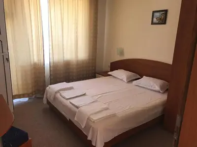 a bedroom with a large bed with white sheets at Family Hotel Diana in Pomorie