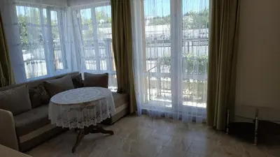 a living room with a couch and a table and windows at Complex Argo in Ravda