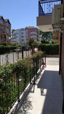 a black fence with flowers next to a sidewalk at Complex Argo in Ravda