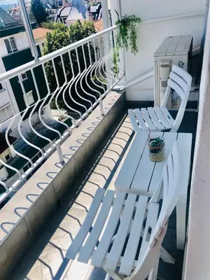 a pair of white chairs sitting on a balcony at Colorful 1-BDR Apartment - Top center of Burgas by Flаt Manаger in Burgas City