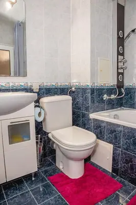 a bathroom with a toilet and a sink and a tub at Colorful 1-BDR Apartment - Top center of Burgas by Flаt Manаger in Burgas City