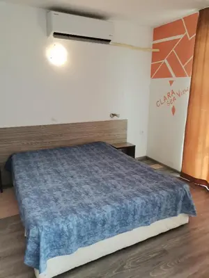 a bedroom with a bed with a blue blanket at Clara Sea View in Burgas City