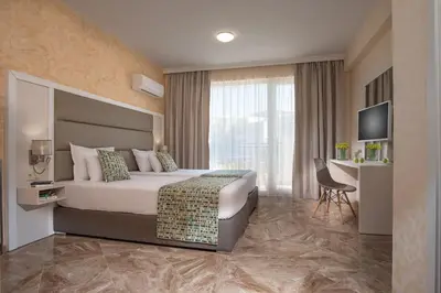 a hotel room with a bed and a television at Marina White Sands Beach Hotel-All Inclusive in Obzor