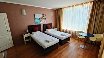 a hotel room with two beds and a table at Favorit Aparthotel in Sunny Beach