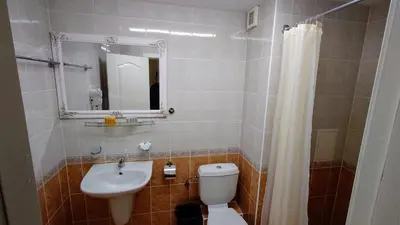 a bathroom with a toilet and a sink and a mirror at Favorit Aparthotel in Sunny Beach
