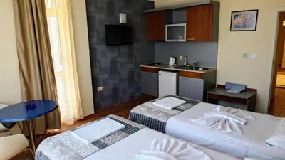 a hotel room with two beds and a kitchen at Favorit Aparthotel in Sunny Beach