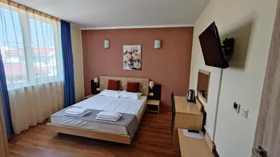 a bedroom with a bed and a flat screen tv at Favorit Aparthotel in Sunny Beach