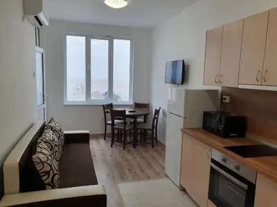 a small kitchen with a table and a dining room at Апартамент Катлена in Pomorie