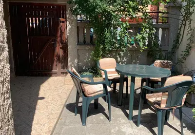 a table and chairs sitting in front of a door at Апартамент Катлена in Pomorie