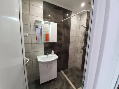 a small bathroom with a sink and a shower at Апартамент Катлена in Pomorie