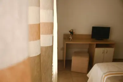 a bedroom with a desk and a desk with a computer at Alba Family Club Hotel in Primorsko