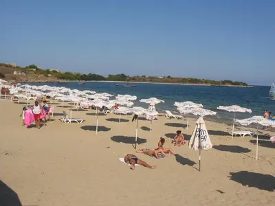 a group of people on a beach with umbrellas at Apartment on the sea at St Nikolas Complex-Ira in Chernomorets