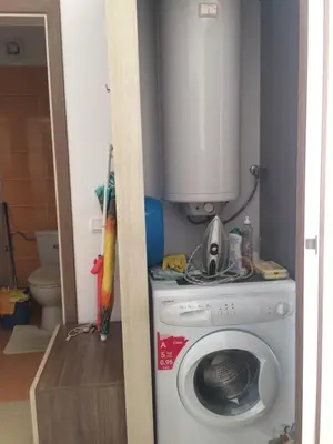 a laundry room with a washing machine and a cabinet at Apartment on the sea at St Nikolas Complex-Ira in Chernomorets