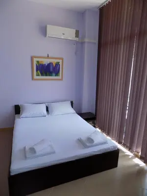 a bedroom with a bed with white sheets and a window at studio Grand Kamelia in Sunny Beach