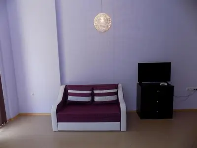 a living room with a purple couch and a tv at studio Grand Kamelia in Sunny Beach