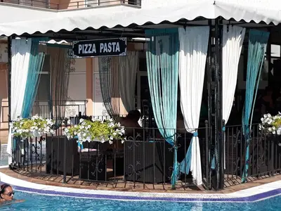 a swimming pool next to a restaurant with a table and a swimming pool at studio Grand Kamelia in Sunny Beach